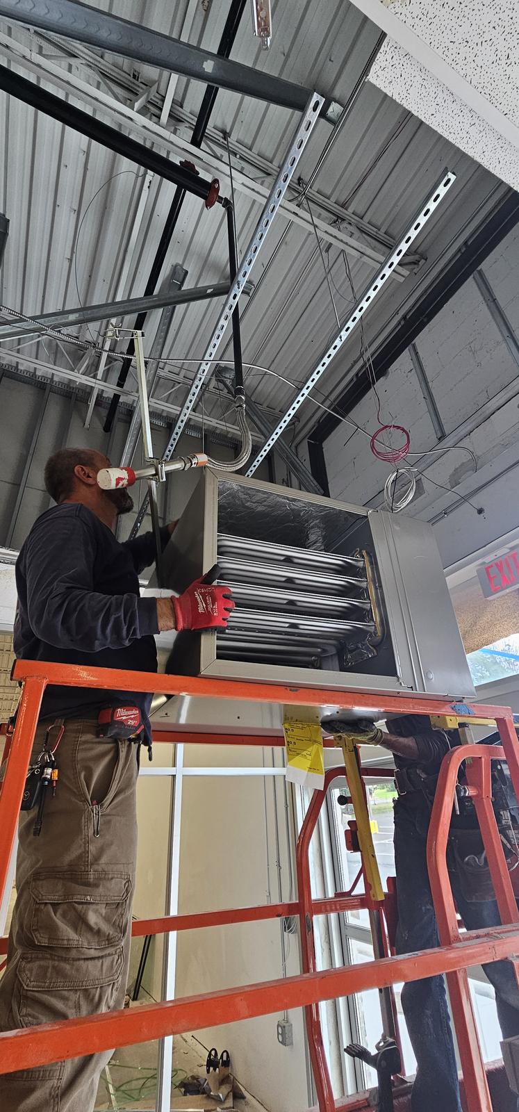 Shepherd HVAC technician installing supply diffusers and grilles overhead