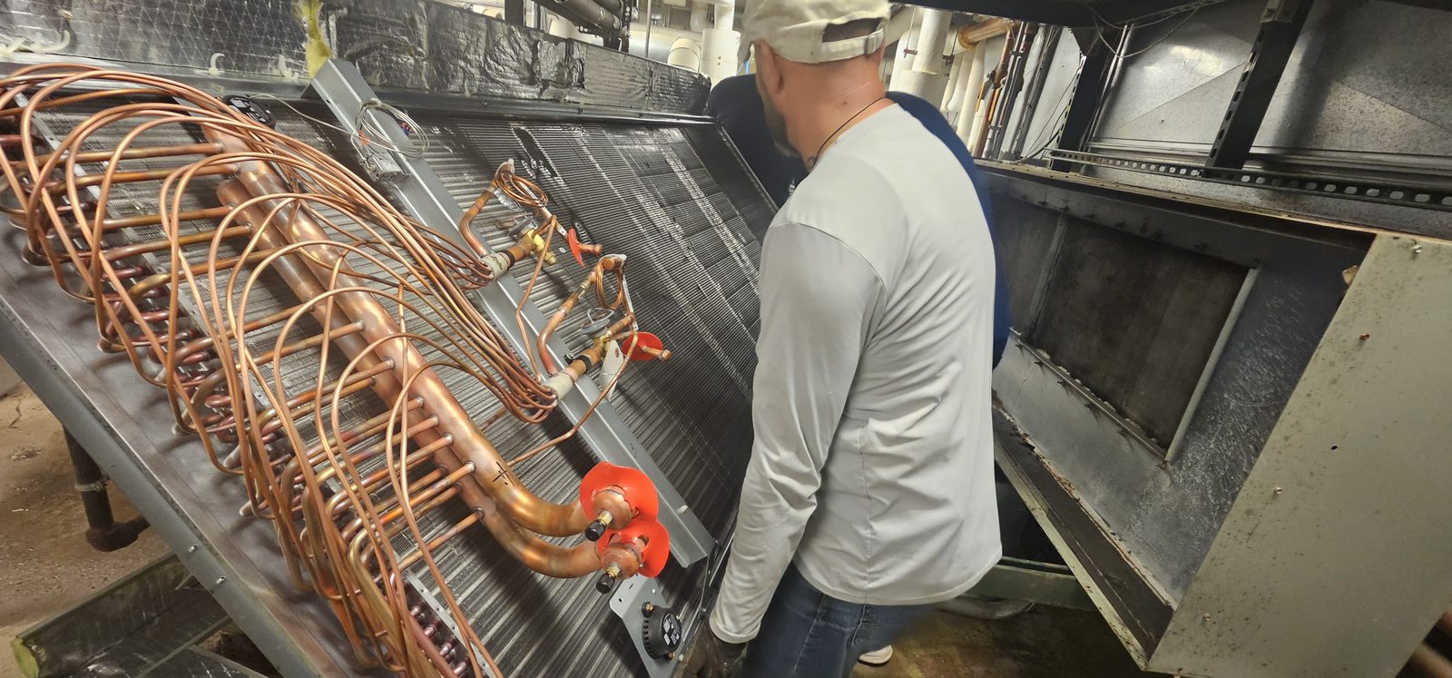 Shepherd HVAC technician working on a copper refrigerant coil circuit during a repair