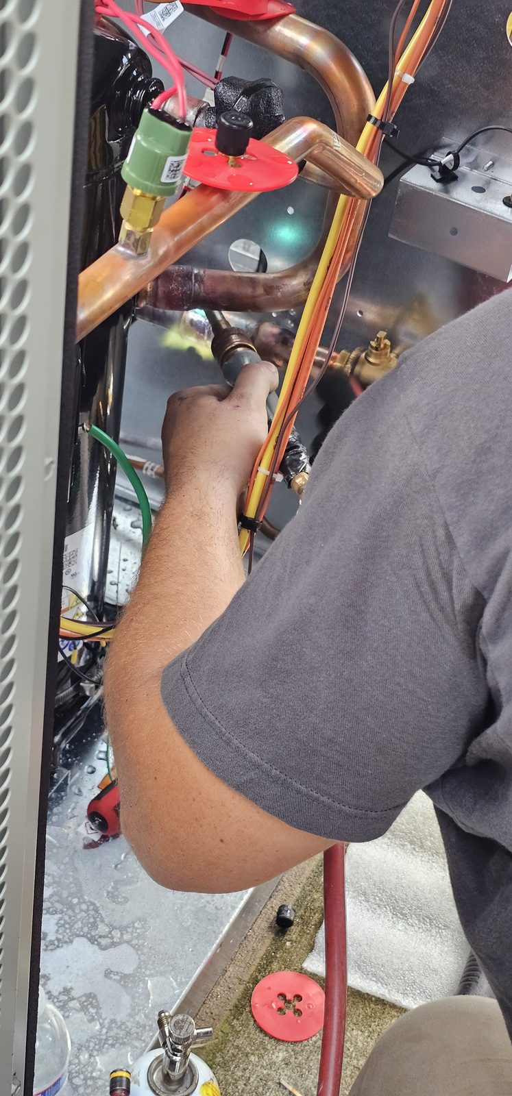 Shepherd HVAC technician brazing copper refrigerant lines during an air conditioning repair