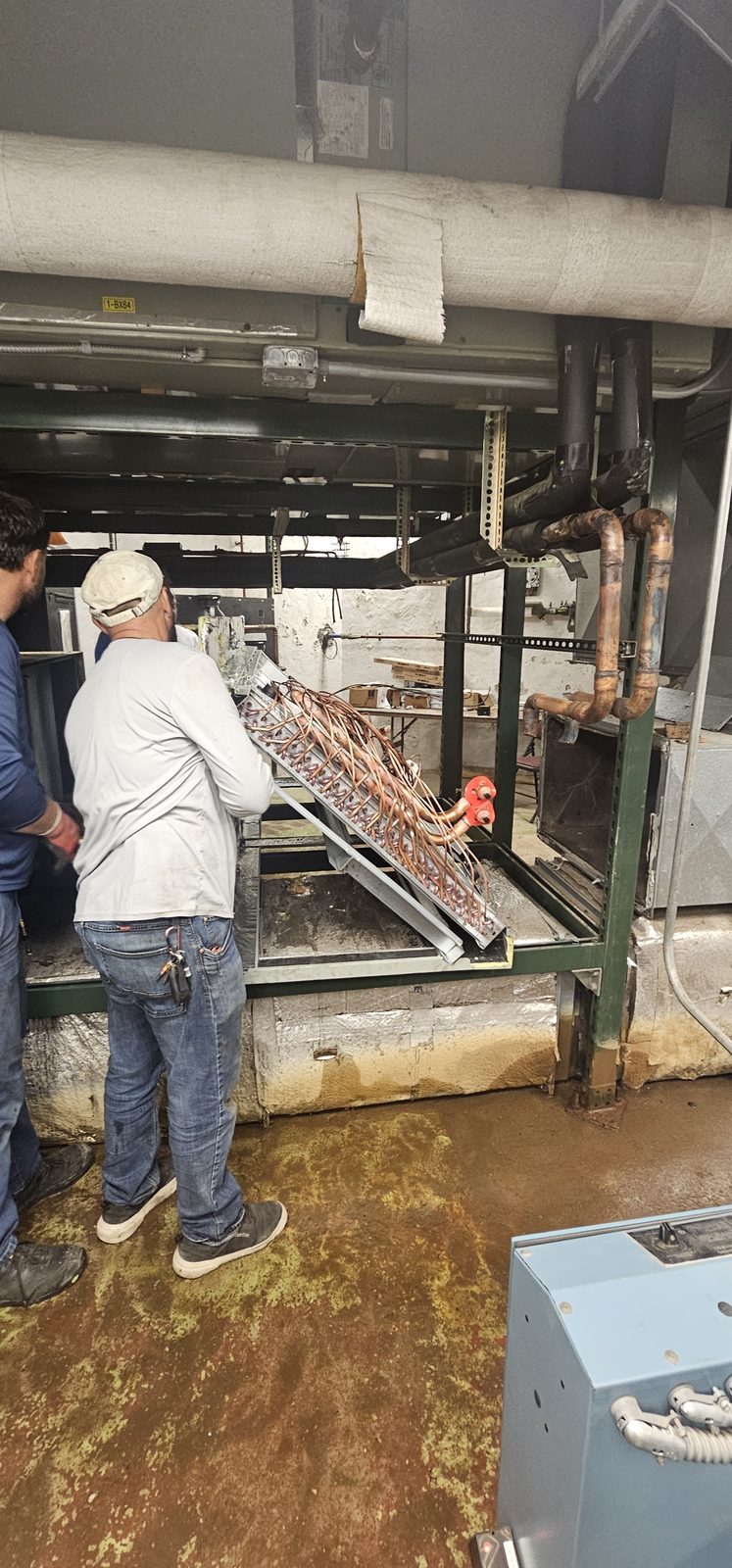 Shepherd HVAC technician assembling an air handler in a building mechanical room