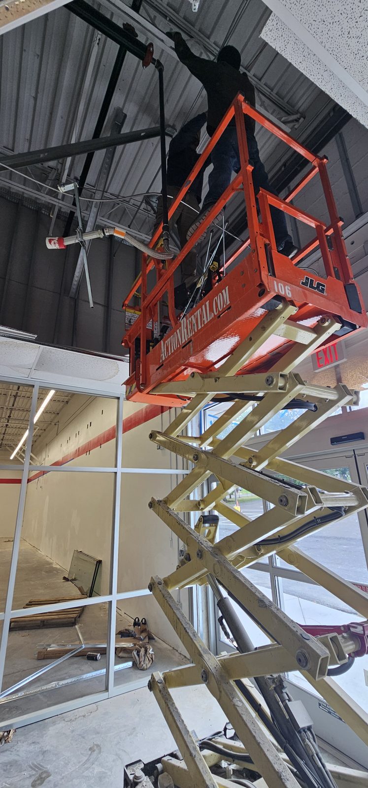 Shepherd HVAC technician installing overhead ductwork from a scissor lift