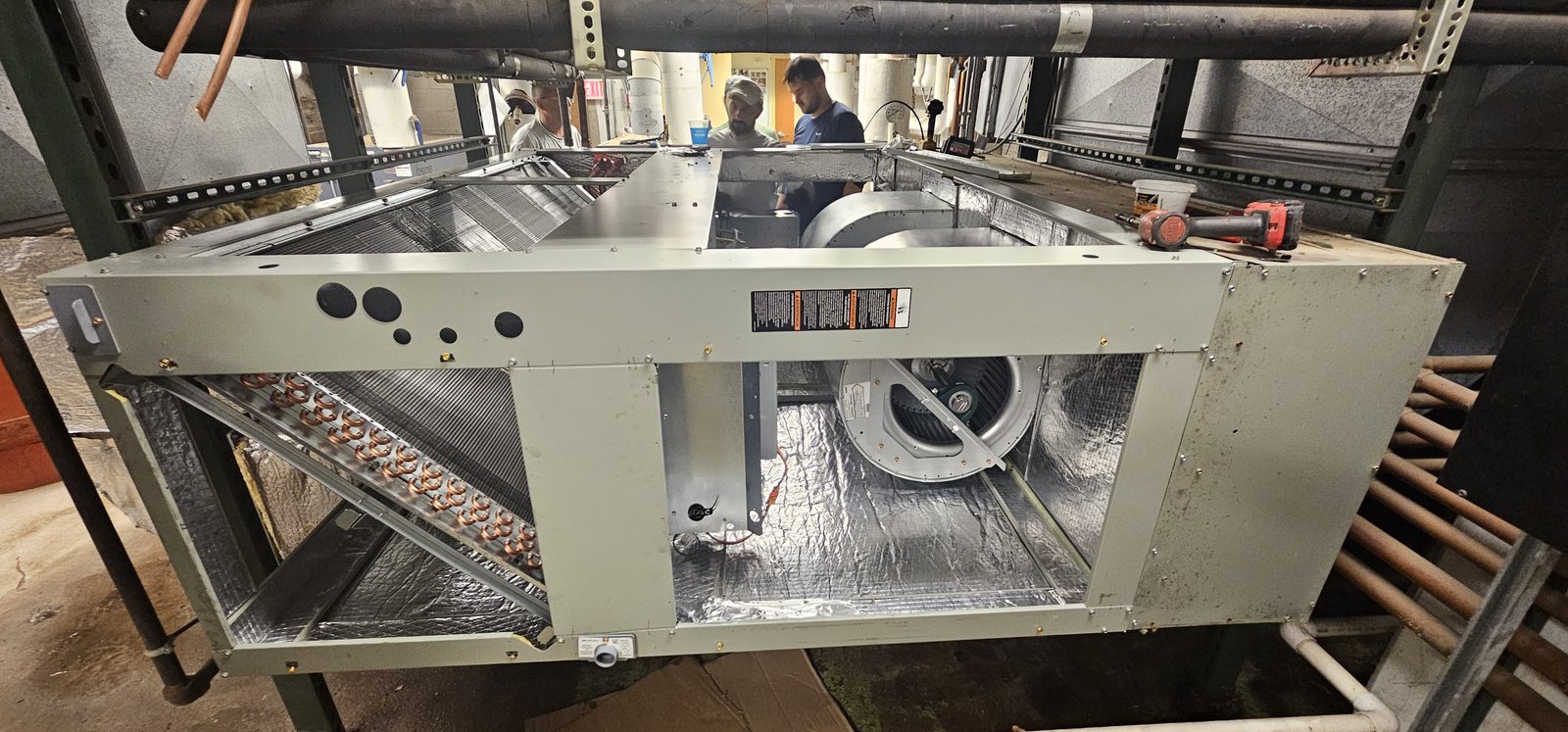 Blower assembly and coil visible inside an open air handler during installation
