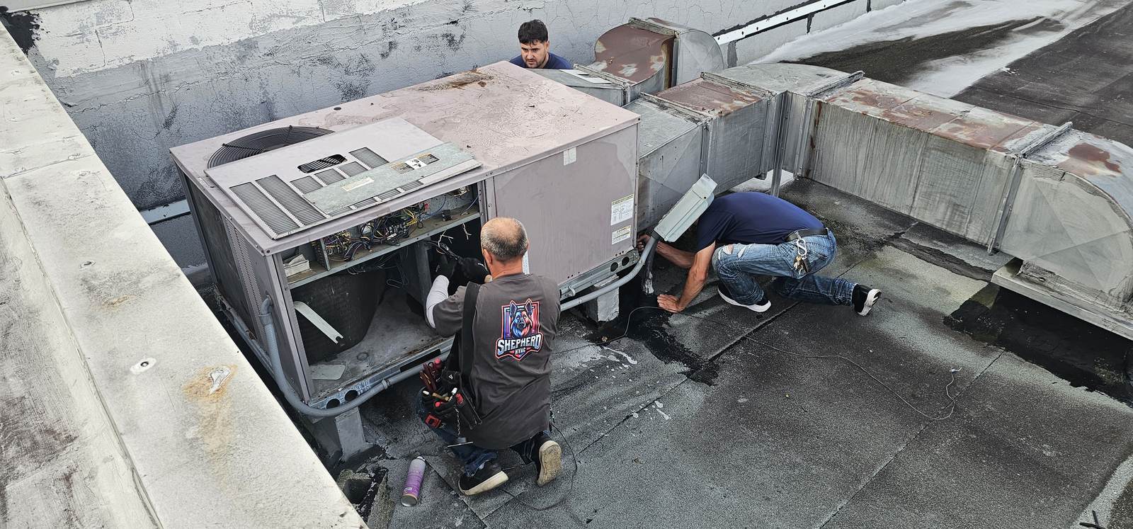 Shepherd HVAC technicians opening a rooftop unit to diagnose a no-cooling call